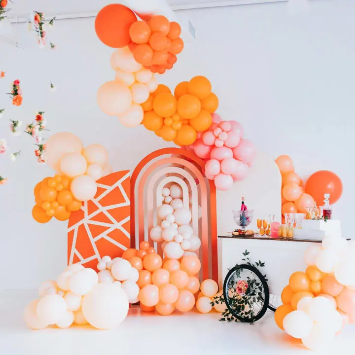 a room filled with balloons and a table with a clock and a bunch of balloons in the air above it