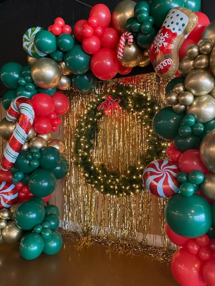 a christmas wreath made out of balloons and streamers with a wreath on the front of the door and a wreath on the back of the front of the door