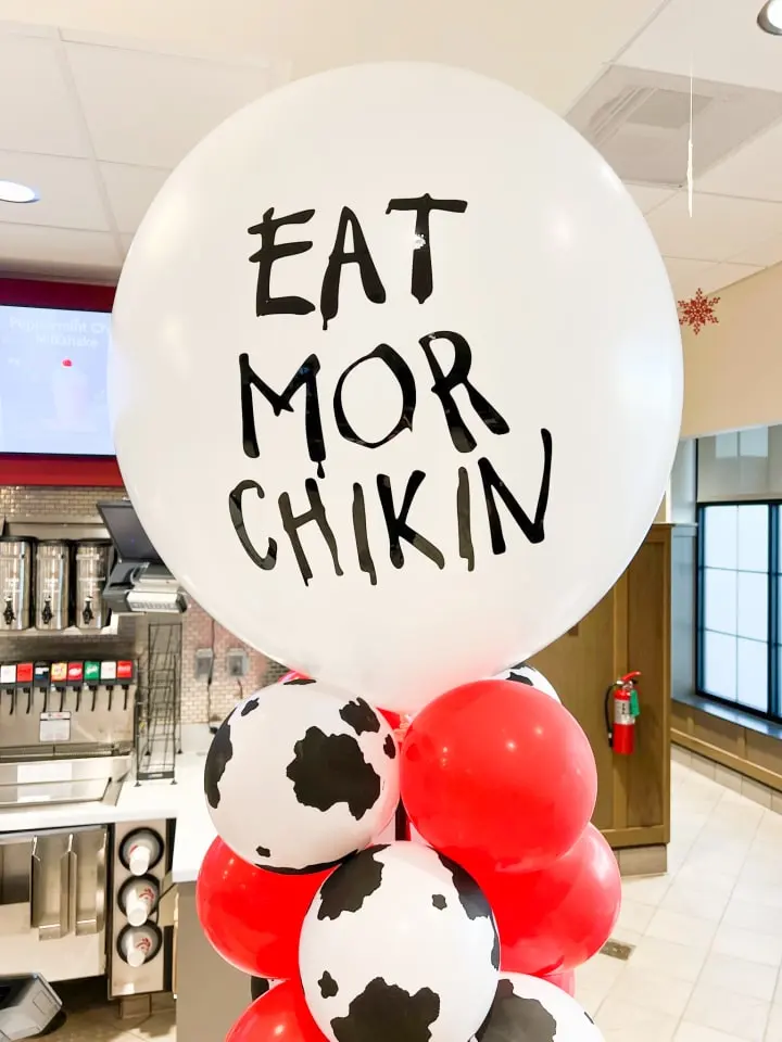 a bunch of balloons with the words eat morr chikin written on them in black and white and red
