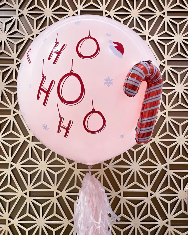 a balloon with the words oh oh on it hanging from a wall with a tasseled scarf on it