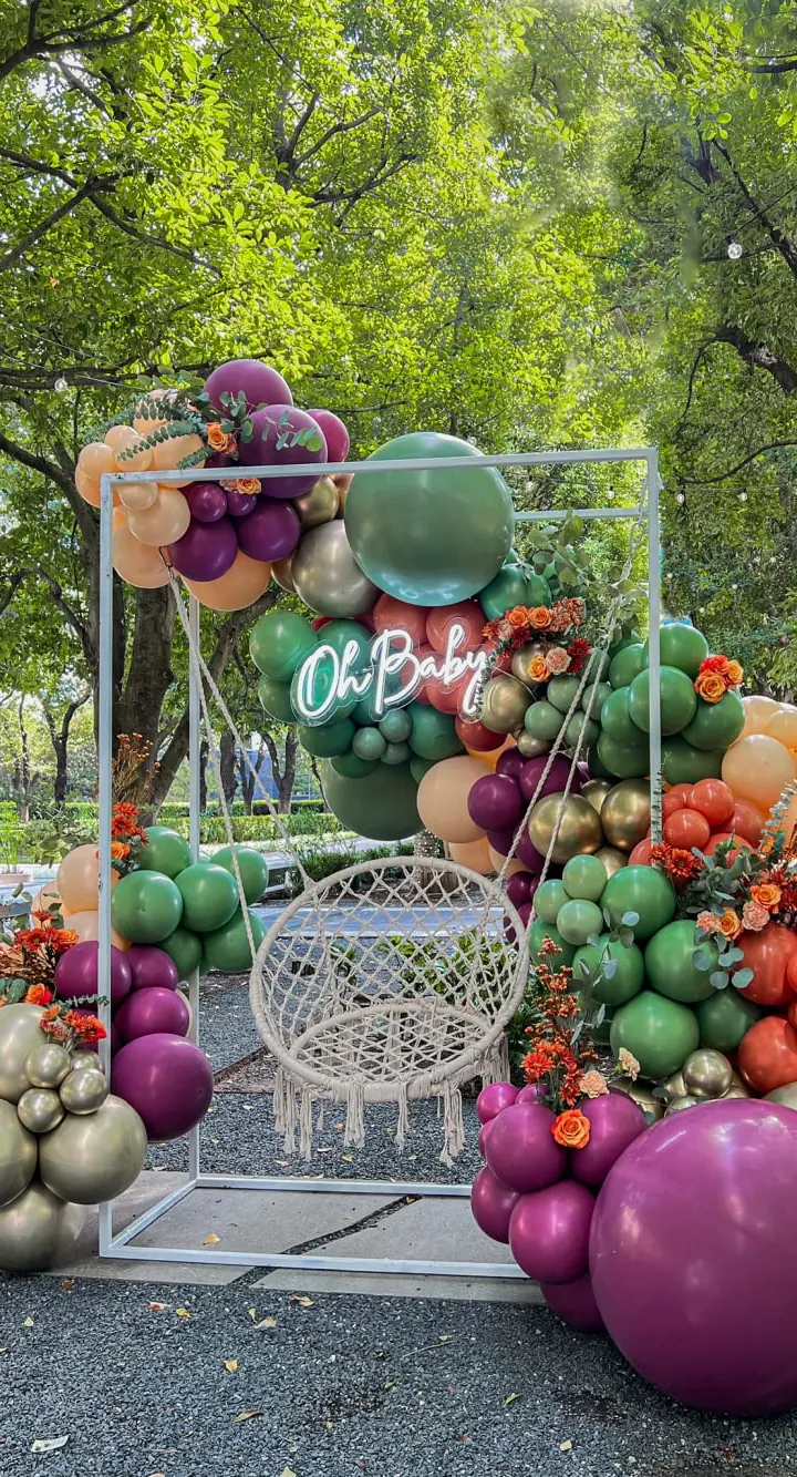 A vibrant display of various fresh fruits and vegetables, including tomatoes, eggplants, and other produce, arranged in an artistic manner against a backdrop of lush, green foliage.