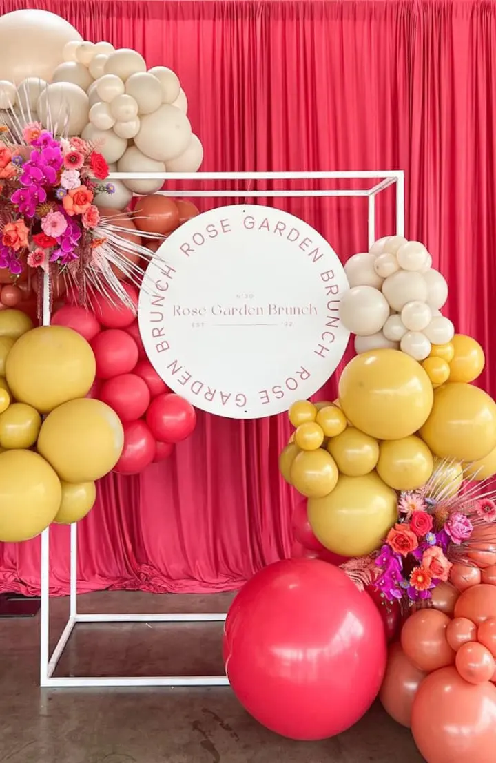 A vibrant and colorful display of various fruits and flowers, set against a backdrop of red curtains, creating a visually striking and festive atmosphere.